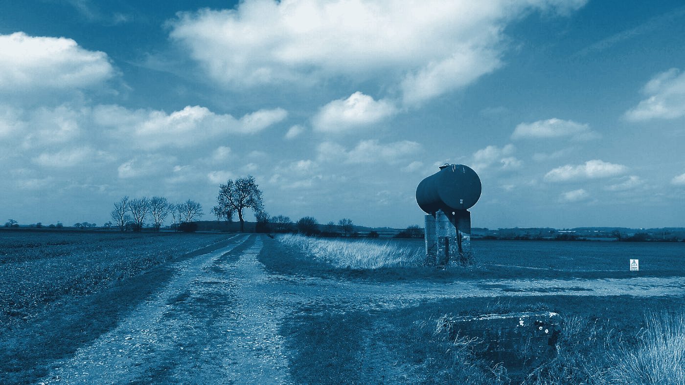An elevated fuel tank beside farm tracks