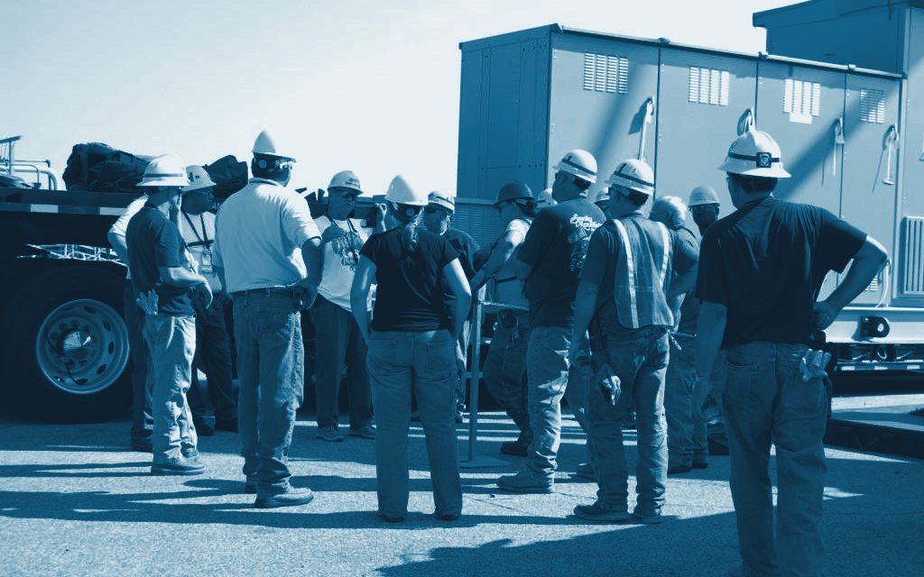Workers in hard hats gathered for a safety briefing on site