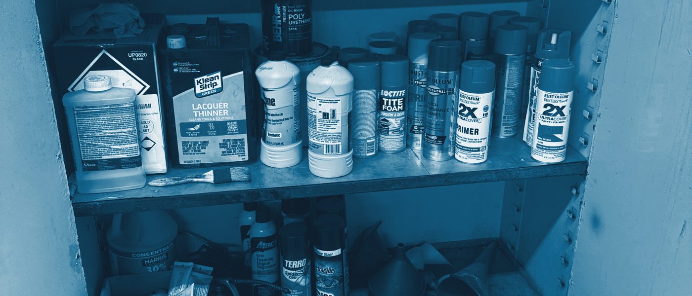 Paints, solvents and aerosols on workshop shelves
