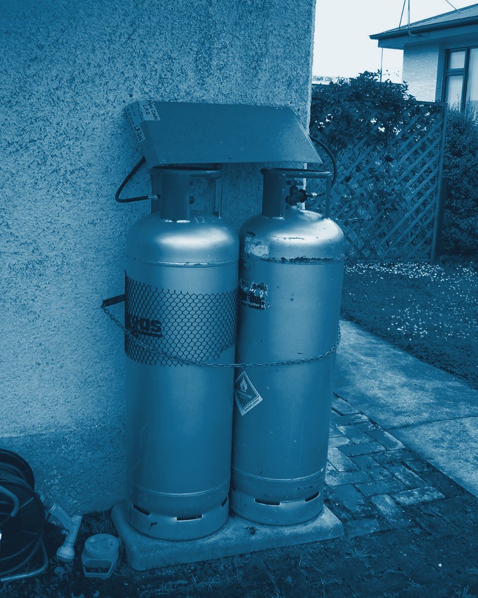 Two 45 kg LPG cylinders chained to a wall outside a building